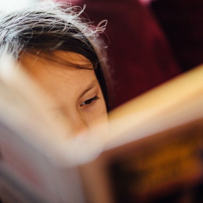 ein Kind ließt in einem Buch