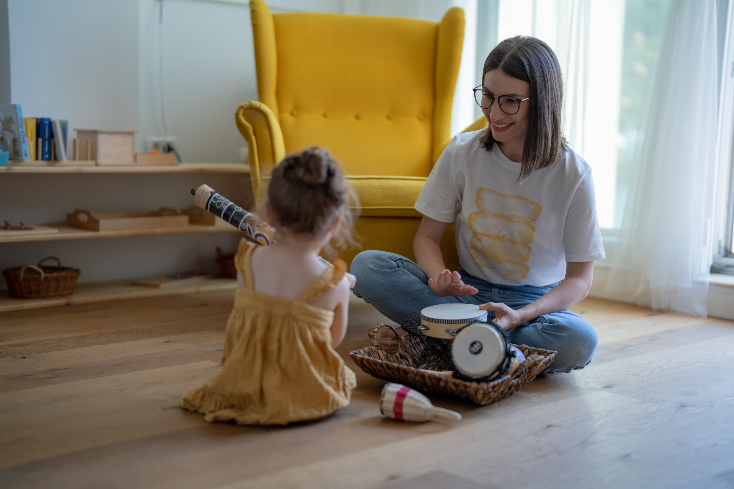 Eine Frau und ein Kind probieren Musikinstrumente aus.