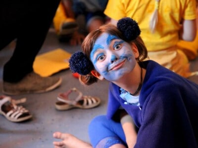 Ein Kind ist als blaue Katze geschminkt