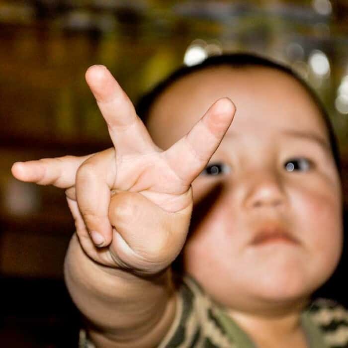 Ein kleines Kind hält seine Finger in die Kamera.