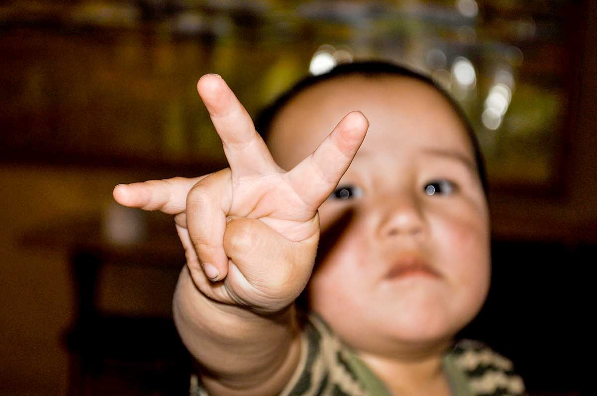 Ein kleines Kind hält seine Finger in die Kamera.
