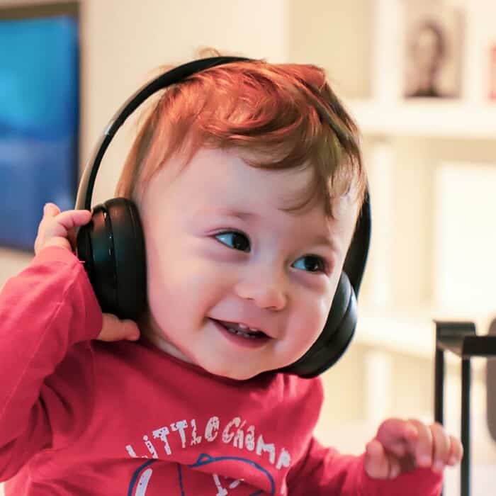 ein Kind hat Kopfhörer auf und lächelt