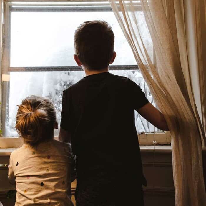 Ein Junge und ein Mädchen schauen aus dem Fenster.