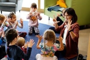 Kinder lernen mit einer Erzieherin zählen mit den Händen.