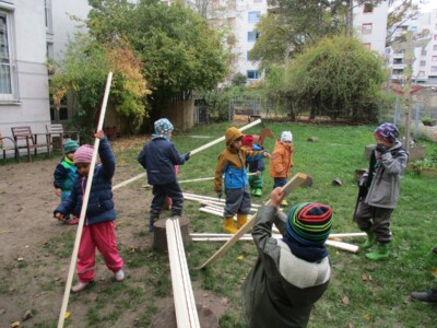 Einige Kinder tragen Holzlatten.