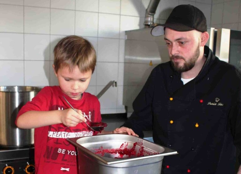 Ein Kind hilft dem Koch