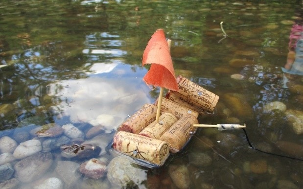 Ein selbstgebautes Boot aus Korken schwimmt auf dem Wasser.