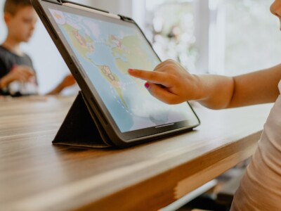 Ein Kleinkind beschäftigt sich an einem Tablet mit einer digitalen Anwendung.