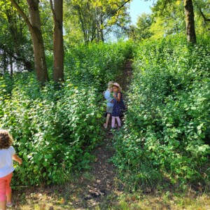 Zwei Kinder an einem kleinen Hügel in der Natur.