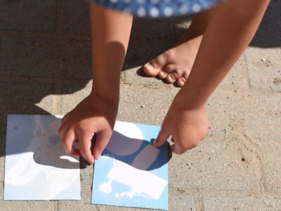 Kind legt zwei Karten auf Steinboden