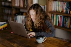 Eine Schülerin sitzt an ihrem Laptops und arbeitet.