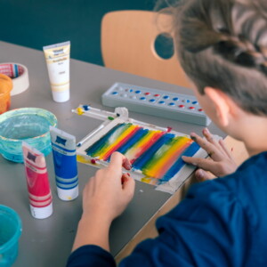 Ein Kind malt etwas mit Fingerfarben