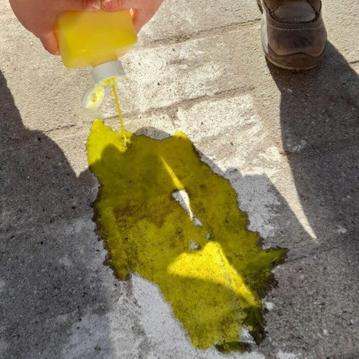 Ein Kind schüttet gelbe Farbe auf die Straße.